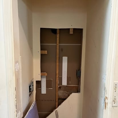 Damaged drywall with hole before repair
